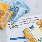 Plusieurs billets de 50 et 20 euros sont étalés sur une surface de marbre blanc à côté d'un document fiscal français provenant de l'administration fiscale de la République française.